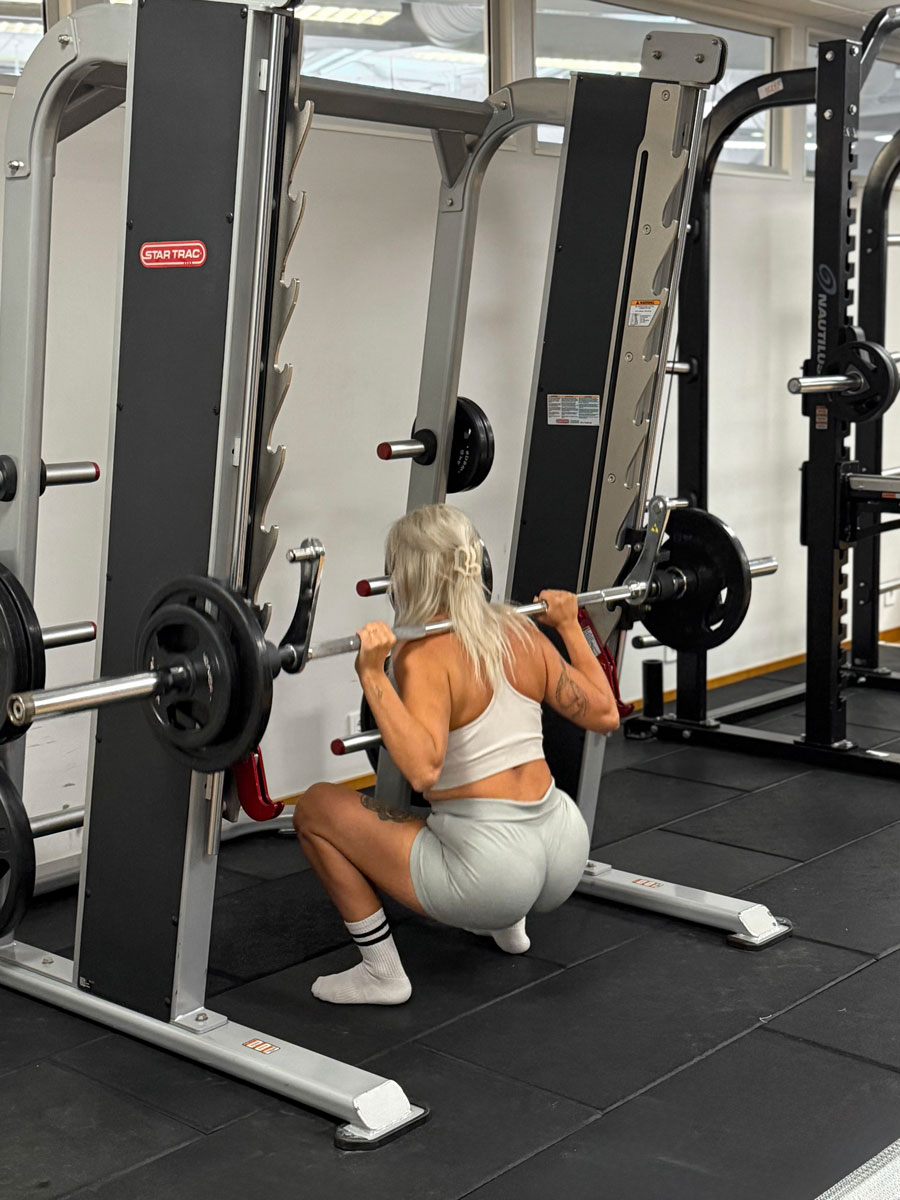 Tränaren tränar på gymmet.